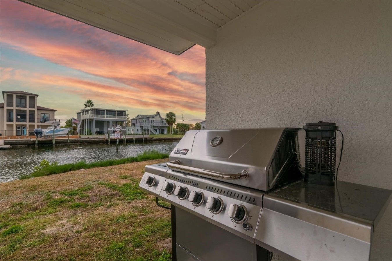 Ein Grill mit Blick auf einen Kanal und Häuser im Hintergrund.