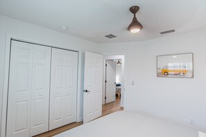 A hallway with white doors, a ceiling fan, and a framed picture on the wall. - Hernando Beach Breeze | Waterfront Hot Tub, Kayaks (Hernando Beach)