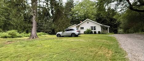 Una casa con entrada para coches y un automóvil estacionado en la parte delantera.
