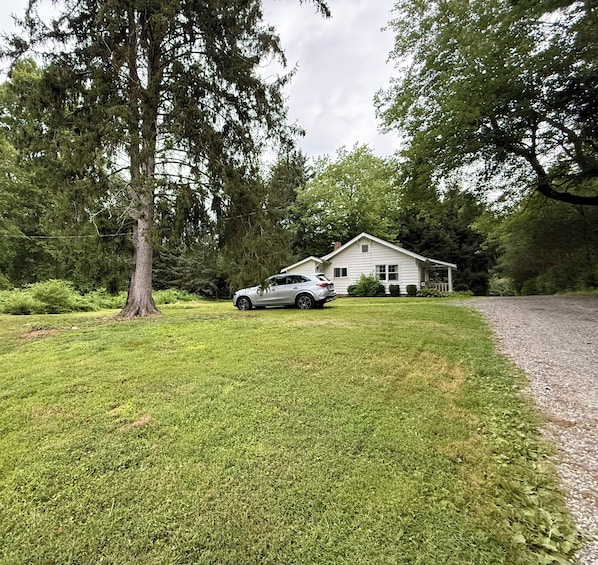 A house with a driveway and a car parked in front.