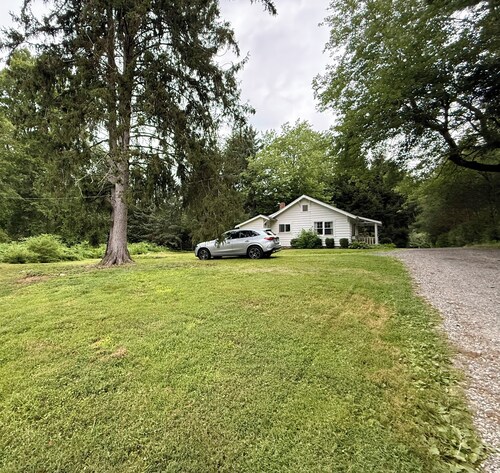 Cottage nestled in wooded Greenwich setting with New England charm