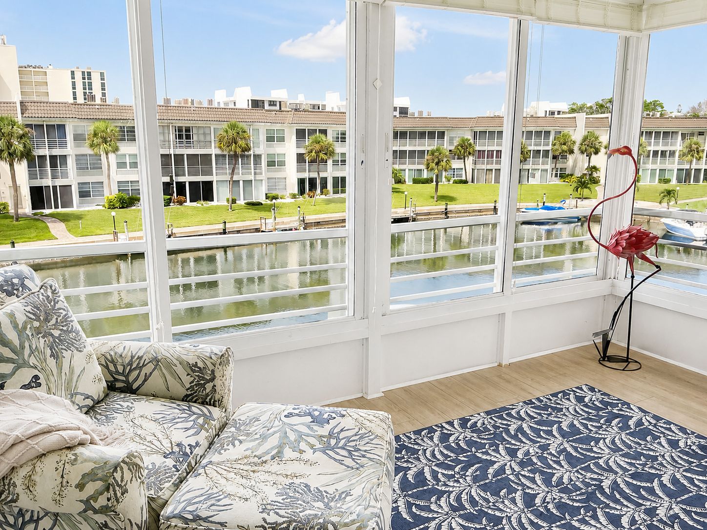A room with a large window overlooking a water body and a building complex.