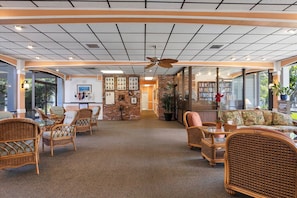 A spacious lobby with wicker furniture, a ceiling fan, and a bookshelf. - 1 Bedroom , 1 Bath Waterview Condo on Longboat Key (Longboat Key)