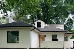 A two-story house with a number '308' on the front door, surrounded by trees. - Luxurious 4-bedroom house in charming neighborhood close to downtown Greensboro. (Greensboro)