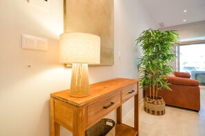 A wooden console table with a lamp and a potted plant. - Los Colibríes by H - Isla Canela Golf GLHC7023P98 (Ayamonte)