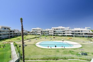 A modern hotel with a central pool, multiple balconies, and a well-maintained lawn. - Los Colibríes by H - Isla Canela Golf GLHC7023P98 (Ayamonte)