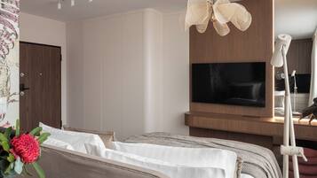 Un dormitorio moderno con cama, televisor y un ventilador de techo original.