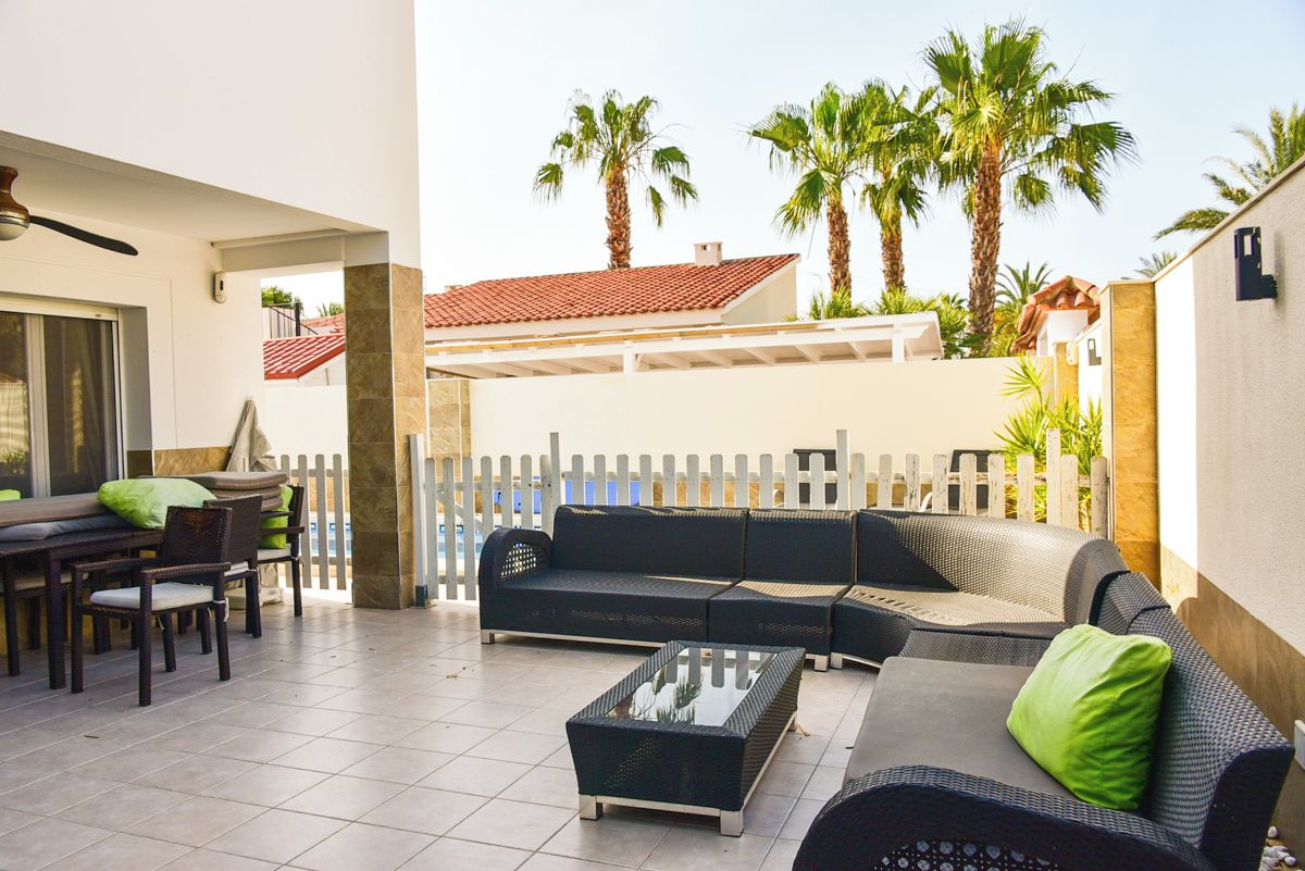 Eine Außenpatio-Terrasse mit einer Sofagruppe, einem Esstisch und Stühlen.