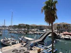 A marina with boats docked, a pedestrian bridge, and buildings in the background. - Port Fréjus: magnificent 1-bedroom apartment with a harbor view, sleeping 4; lively area, air-conditioned, with Wi-Fi and parking. (Fréjus)