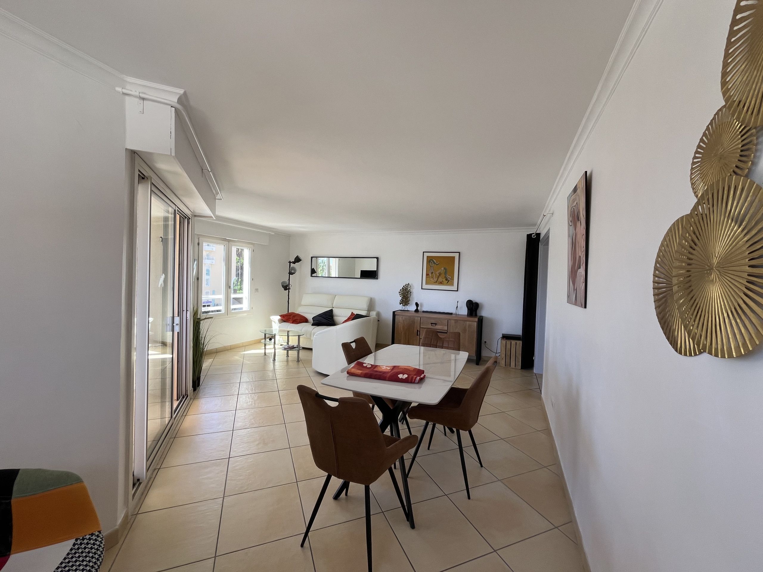 A modern living room with a dining area, a sofa, a coffee table, and a TV.