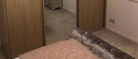 Une chambre à coucher avec un lit, une armoire et une commode.