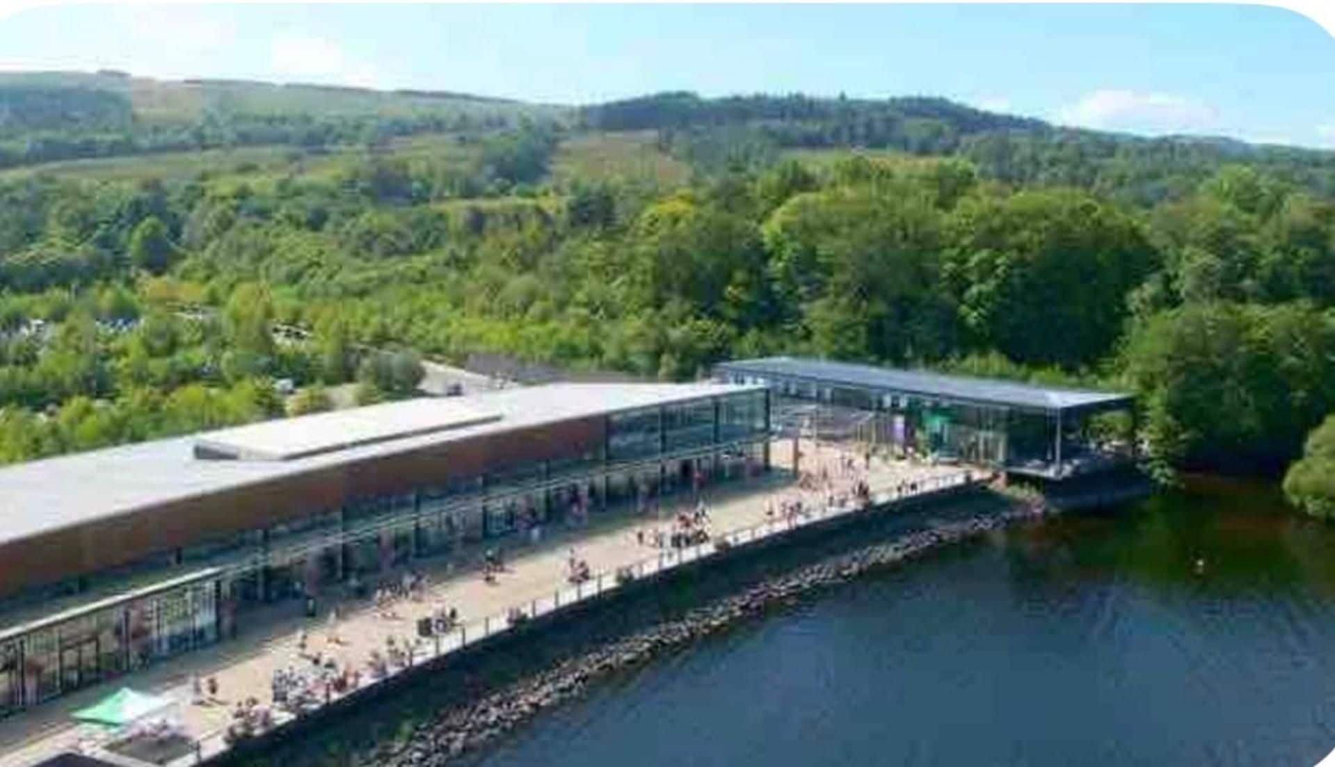 A riverside building with a long covered walkway and a glass facade.
