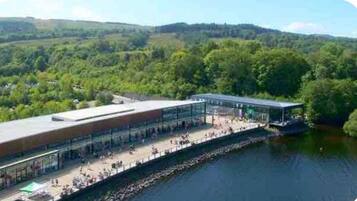 A riverside building with a long covered walkway and a glass facade.