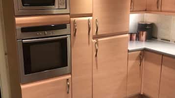 Una cocina con microondas, horno y armarios.