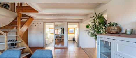 A modern interior with a wooden staircase, a dining area, and a kitchen.