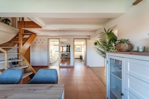Ein modernes Interieur mit einer Holztreppe, einem Essbereich und einer Küche.