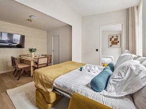 Une chambre d’hôtel équipée d’un lit, d’un bureau et d’un téléviseur fixé au mur.
