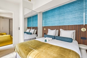 A modern hotel room with a large bed, a bedside table, a mirror, and a view of the hallway. - Lavie Maison – Hot Tub & AC – Central Paris (Paris)