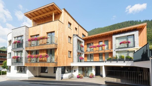 A multi-story building with balconies, wooden facade, and flower boxes. - Anthonys Peaks and Pillows St Anton (Sankt Anton am Arlberg)
