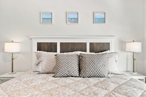 A bedroom with a bed, two bedside lamps, a headboard, and three framed pictures on the wall. - Choose Happiness Updated 4 BR short golf cart ride Pawleys Pet Friendly (Pawleys Island)