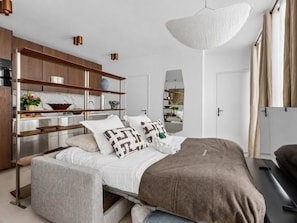 Ein modernes Schlafzimmer mit einem Bett, Nachttischen, einem Kleiderschrank und einem großen Spiegel.