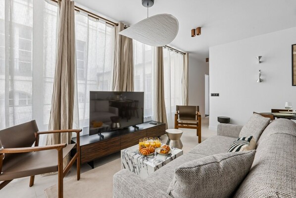 A modern living room with a television, seating, and a coffee table.