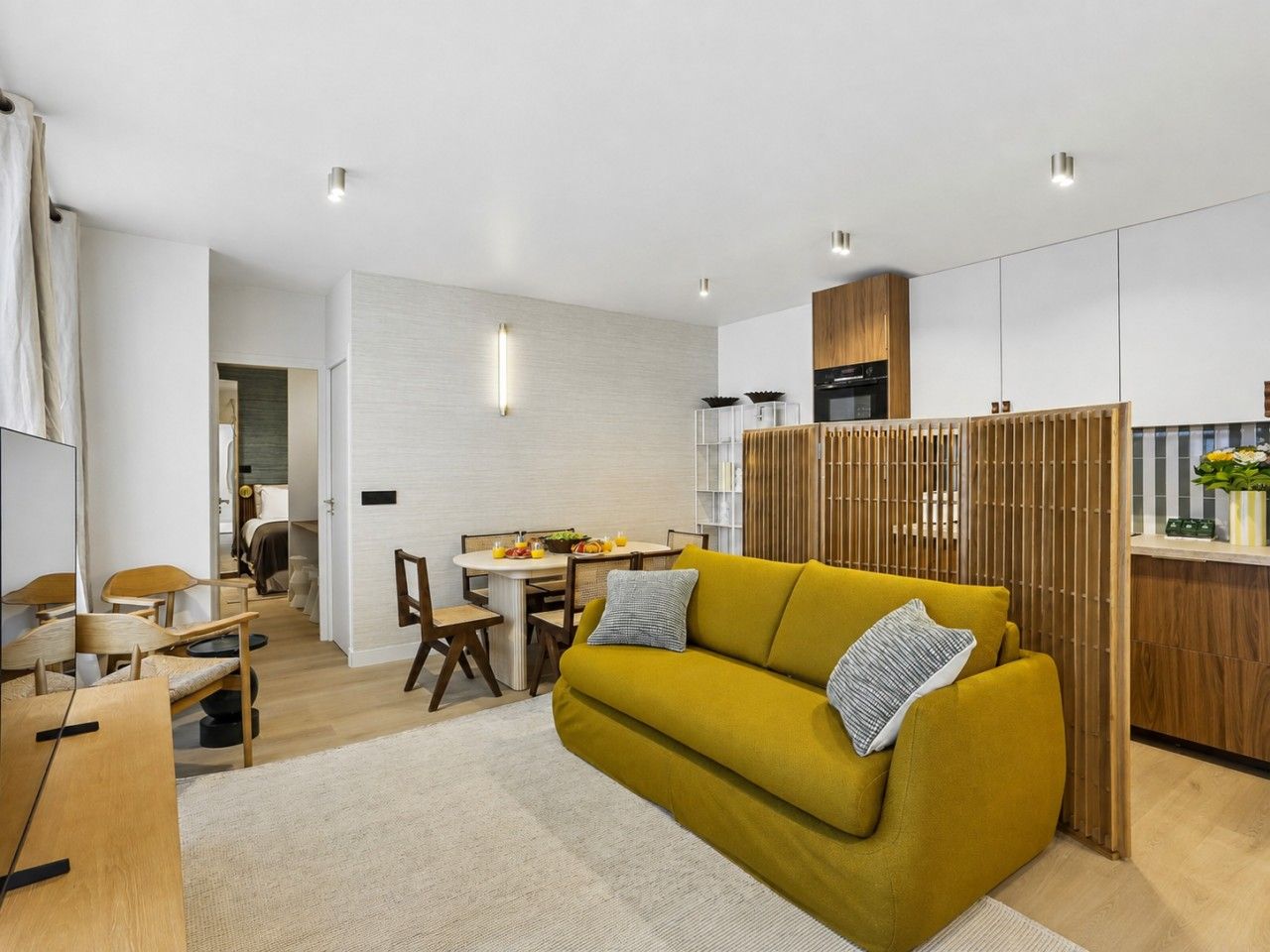 Ein modernes Wohnzimmer mit einer Couch, einem Essbereich und einer Küche.