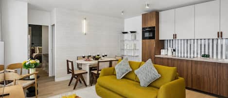 A modern living room with a sofa, coffee table, and dining area.