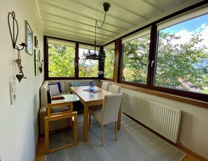 A dining area with a table and chairs, large windows, and a ceiling fan. - Bergulme Vacation Rental with a View of the Tyrolean Mountains (Mutters)