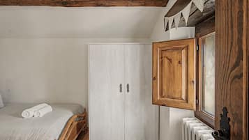 Un dormitorio con cama, armario y radiador.