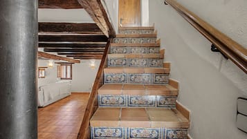 Uma escadaria com azulejos estampados e vigas de madeira.