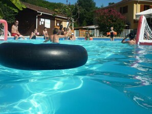 A swimming pool with clear water, a black floating object, and people in the background. - Bungalow, pets welcome - 5 guests (Monplaisant)
