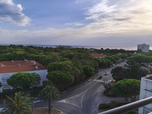 A coastal residential area with a road leading to a beach, surrounded by lush greenery and buildings with red-tiled roofs. - Apartment with sea view - 4 guests (Argelès-sur-Mer)