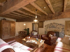 A rustic interior with wooden beams, leather sofas, a stone fireplace, and a dining area. - Spacious lodging with pool - 18 guests (Saint-Just-la-Pendue)