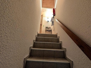 A staircase leading to a room with a shoe rack and a wooden ceiling. - Ski-in/ski-out duplex, pets welcome - 6 guests (Montgenèvre)