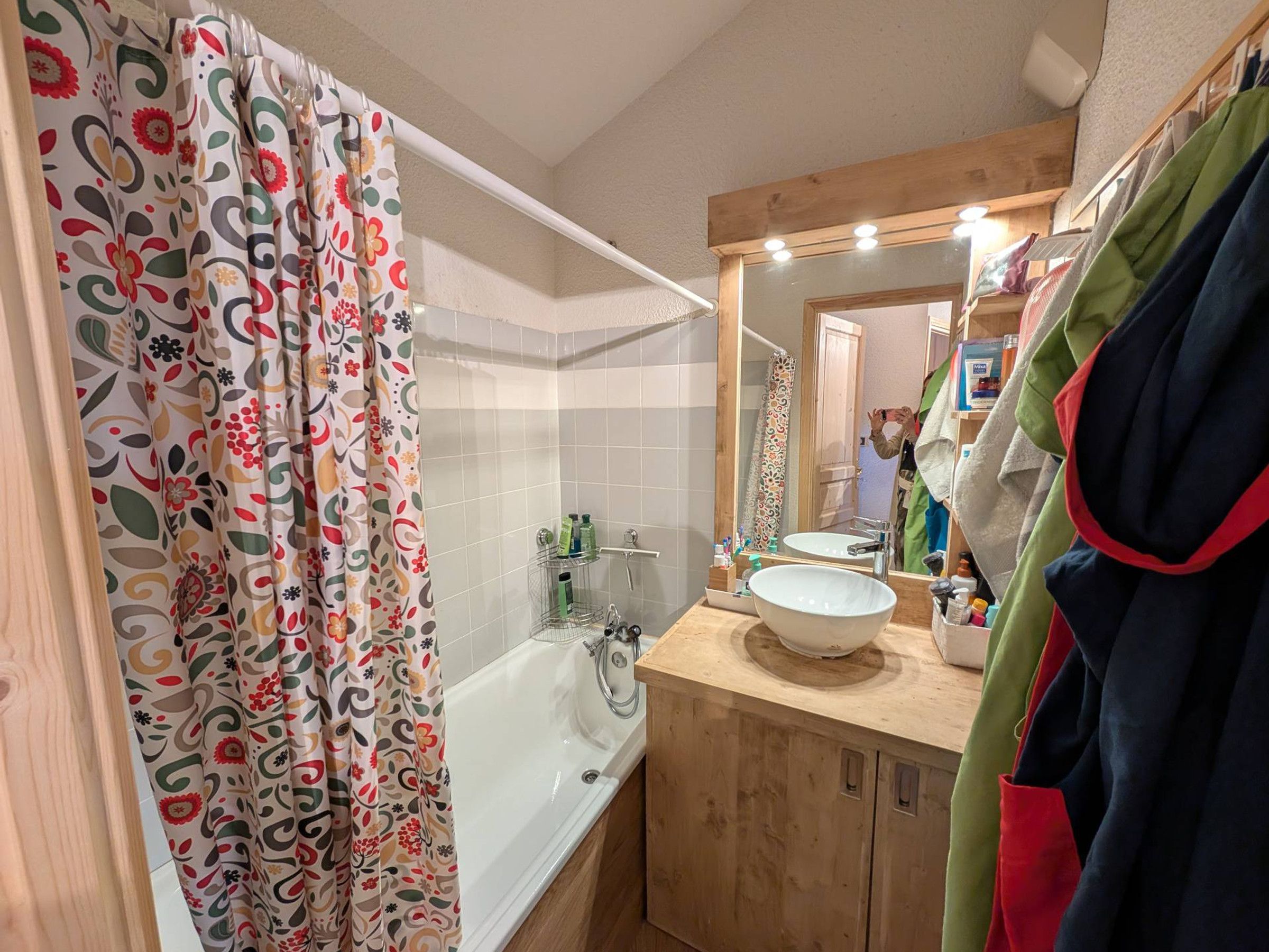 A bathroom with a bathtub, a sink, and a mirror.