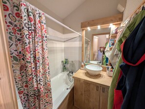 A bathroom with a bathtub, a sink, and a mirror. - Ski-in/ski-out duplex, pets welcome - 6 guests (Montgenèvre)