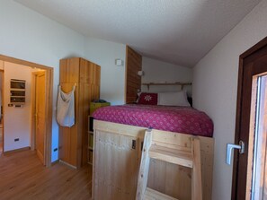 A bedroom with a bunk bed, wooden wardrobe, and a door with a handle. - Ski-in/ski-out duplex, pets welcome - 6 guests (Montgenèvre)