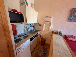 A compact kitchen with a microwave, stove, sink, and refrigerator. - Ski-in/ski-out duplex, pets welcome - 6 guests (Montgenèvre)