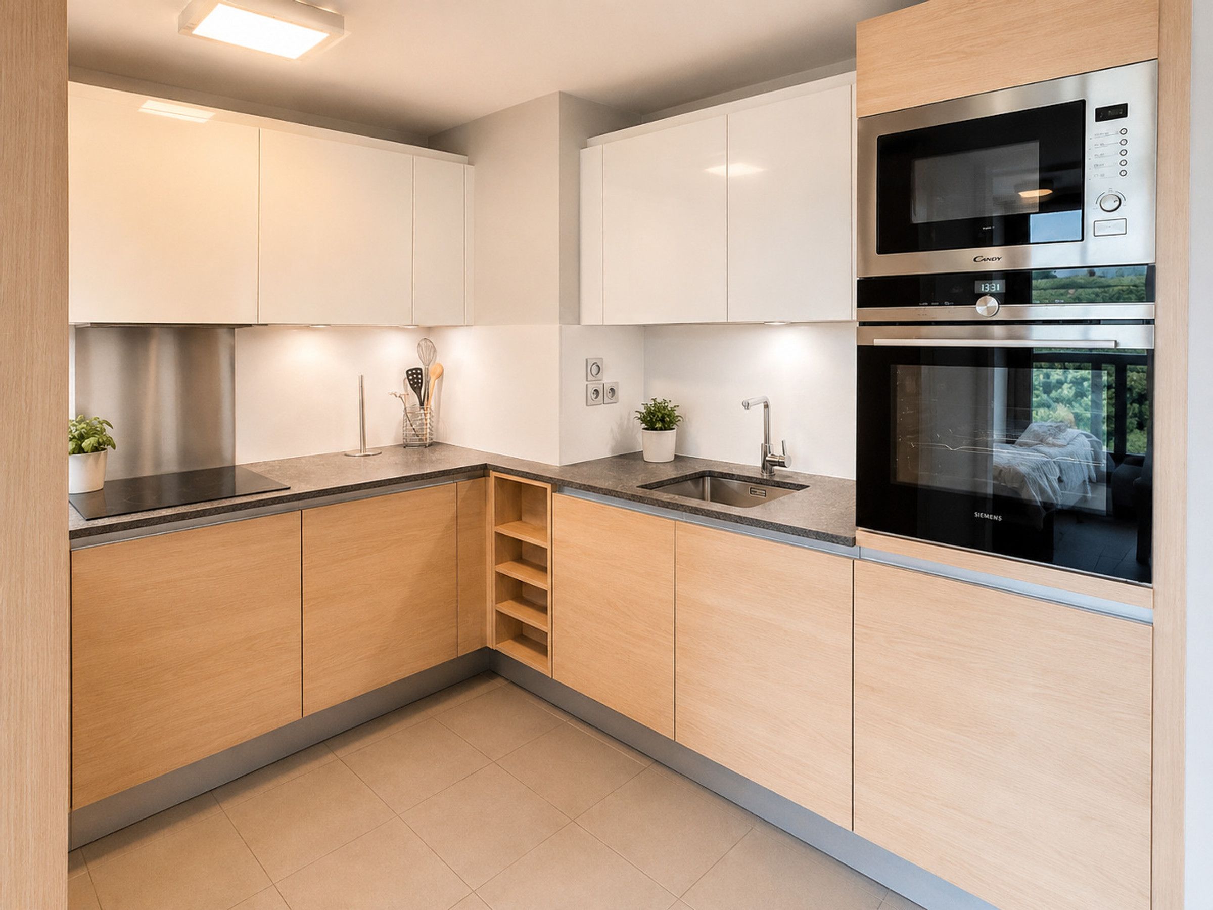 A modern kitchen with white cabinetry, a stainless steel sink, a double oven, and a built-in microwave.