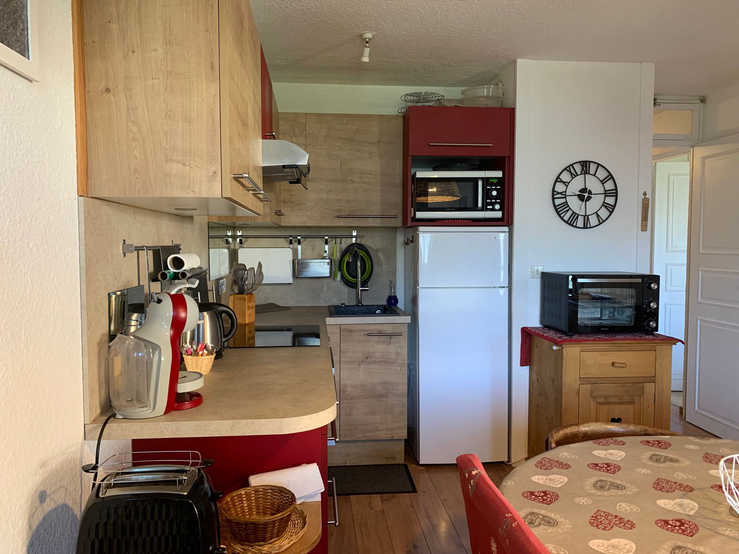 A compact kitchen with a microwave, toaster, and refrigerator.