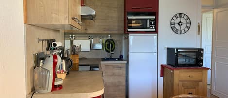 A compact kitchen with a microwave, toaster, and refrigerator.