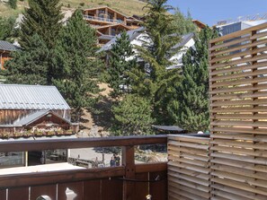 A wooden building with a balcony overlooking a mountainous area with pine trees. - Central apartment with large terrace (Les Deux Alpes)