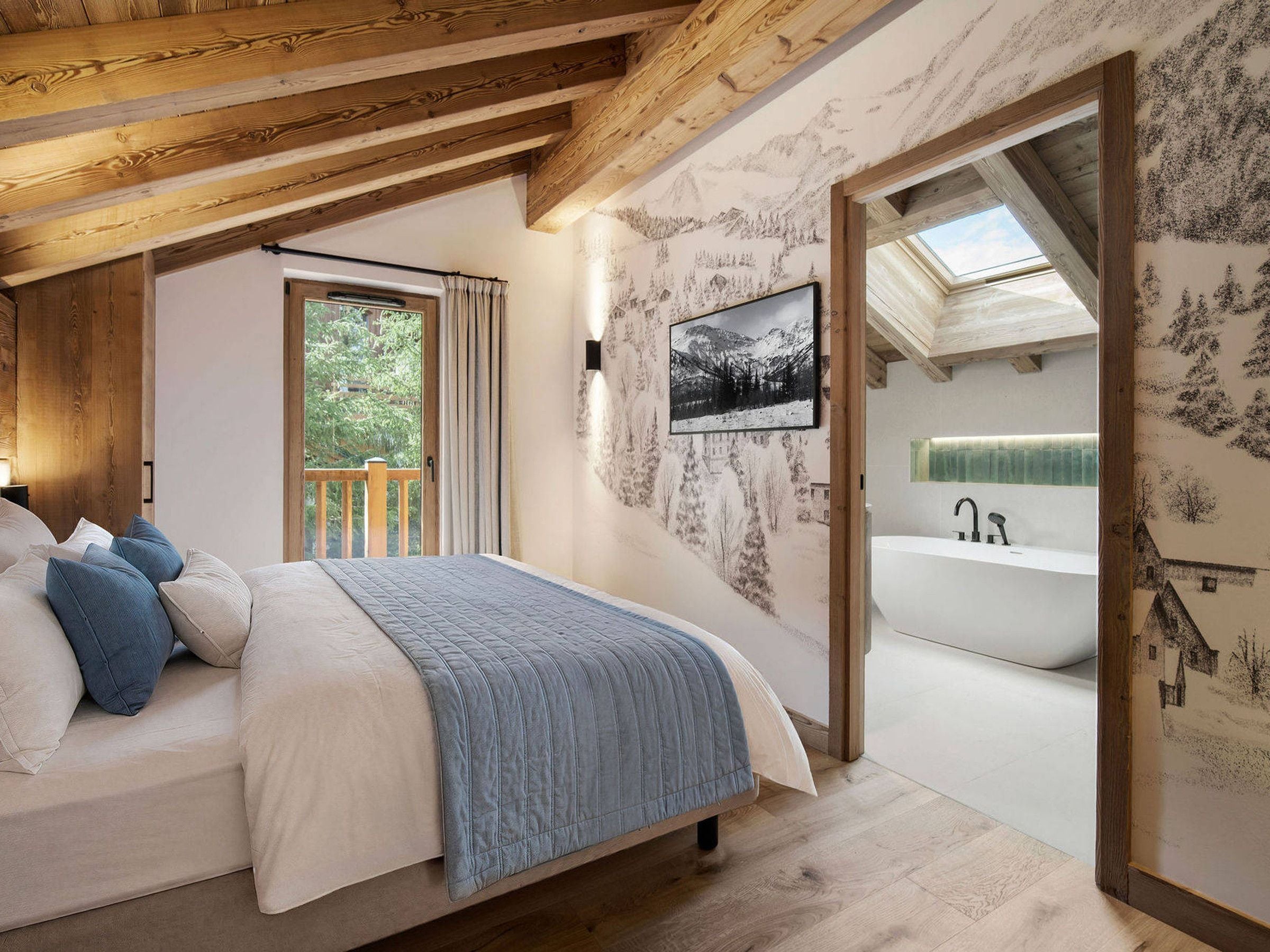 Une chambre à coucher avec un lit, une fenêtre, un tableau accroché au mur, et une salle de bain avec une baignoire.