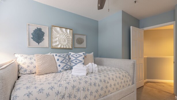 Ein Schlafzimmer mit Bett, Kissen und Wandbildern.