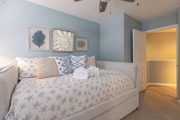 A bedroom with a bed, pillows, and wall art. - 22 Ocean Breeze: 3 Bedrooms, Hosts 6, Walk to Beach! (Hilton Head Island)