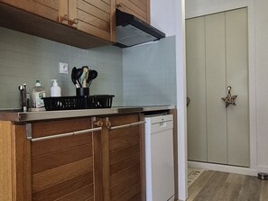 Eine Küche mit Holzschränken, einem Geschirrspüler und einer gefliesten Spritzschutzwand.
