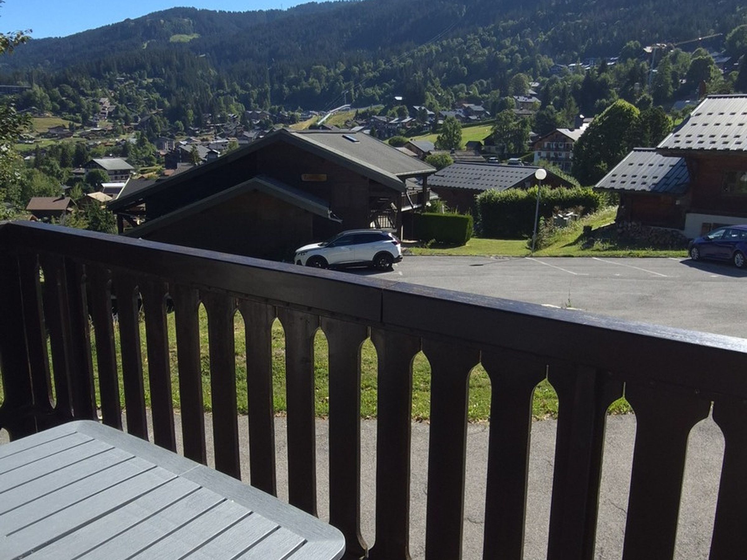 Ein Wohngebiet mit Häusern, einem Parkplatz und Blick auf ein Gebirge.