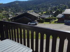 A residential area with houses, a parking lot, and a view of a mountain range. - Charming apartment - 5 guests (Les Carroz d'Arâches)