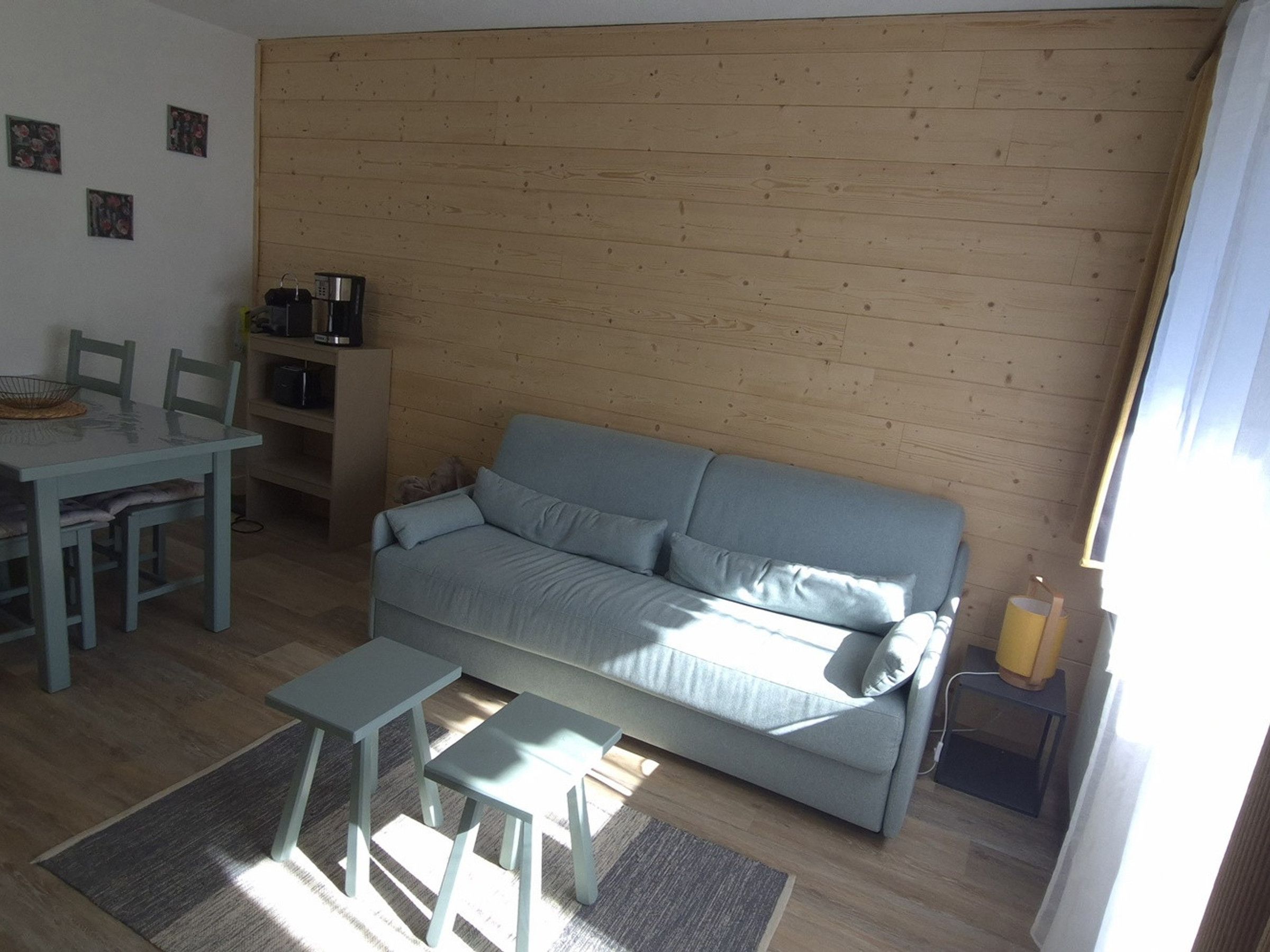 Un salon comprenant un canapé, une table basse et une table à manger avec des chaises.
